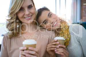 Portrait of female friends sitting together and having coffee