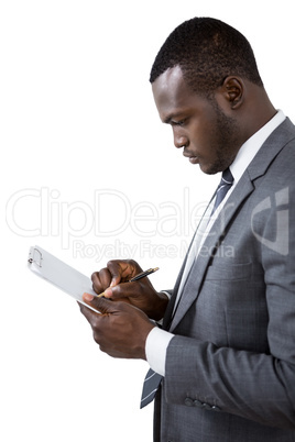 Businessman writing on clipboard