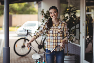 Women standing with bicycle outside the cafeÃ?Â 