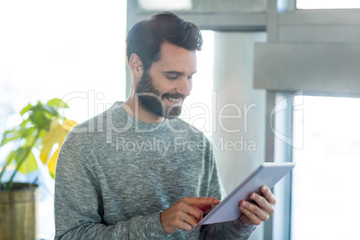 Man standing in cafÃ?Â© and using digital tablet