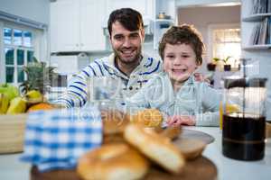 Father and son having breakfast in the kitchen