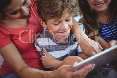 Mother and kids using digital tablet together