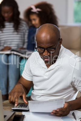 Man using calculator to check the bills
