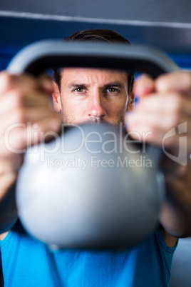 Portrait of serious man showing kettlebell