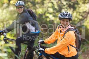 Biker couple riding mountain bike in the forest