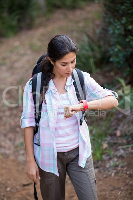 Female hiker looking time on smartwatch