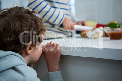 Boy looking while father chopping vegetables
