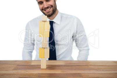 Businessman placing wooden block on a tower