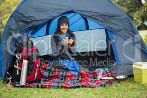 Portrait of smiling hiker having a cup of coffee in tent
