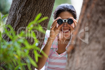 Female hiker looking through binoculars