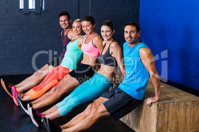 Male and female athletes exercising on wooden box