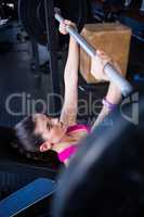 Young female athlete lifting barbell