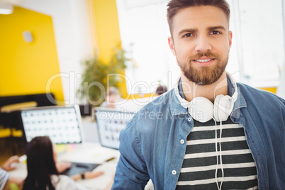 Portrait of handsome executive with headphones at creative office