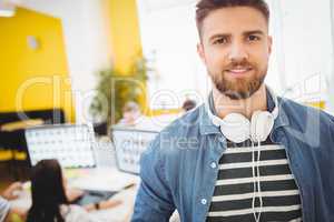 Portrait of handsome executive with headphones at creative office