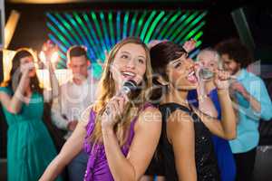 Two beautiful women singing song together