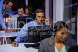 Businessman with headsets using computer in office