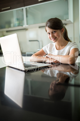 Portrait of smiling girl with laptop in the living room