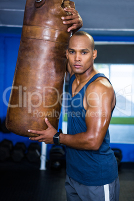 Confident male athlete by punching bag