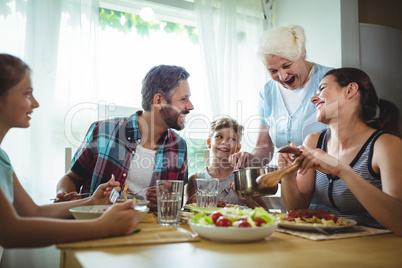 Elderly woman  serving meal to her family