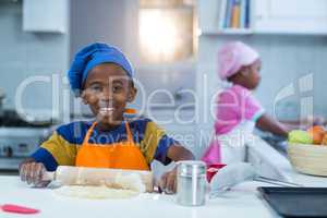 Boy preparing cake with sister in background