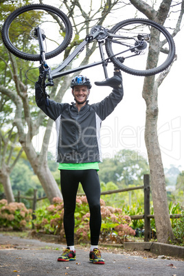 Male cyclist carrying mountain bike