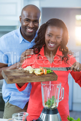 Couple putting fruits in a mixer