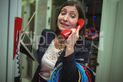 Technician talking on phone while analyzing server