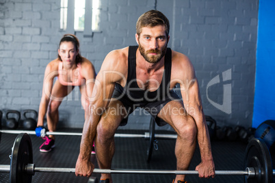 Portrait of athletes lifting barbell