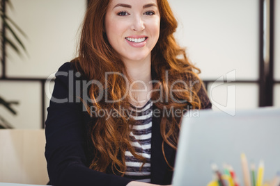 Portrait of confident executive using laptop at office
