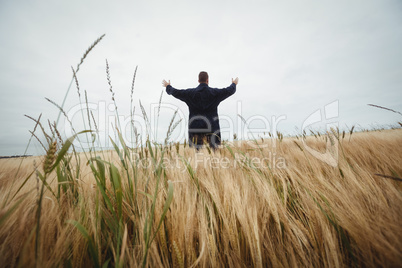 Rear view of farmer standing in the field