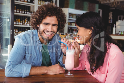 Happy couple drinking milkshake