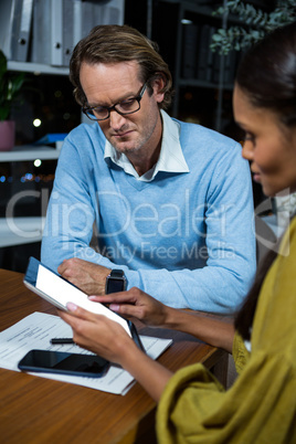 Business executives discussing over digital tablet