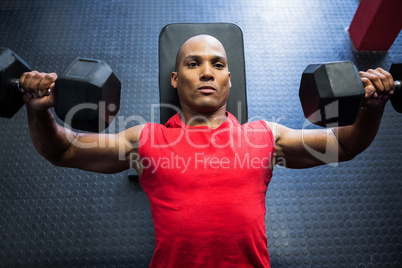 Male athlete exercising with dumbbells