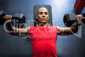 Male athlete exercising with dumbbells