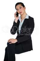 Businesswoman talking on mobile phone against white background