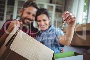 Smiling couple holding keys in their new house