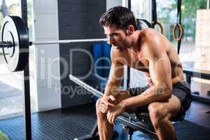 Man sitting on exercise equipment in gym