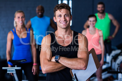 Portrait of smiling gym trainer holding clipboard