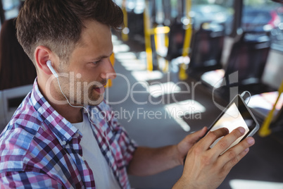 Handsome man listening music on digital tablet