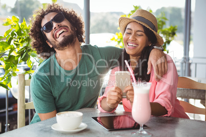 Couple having fun while using mobile phone