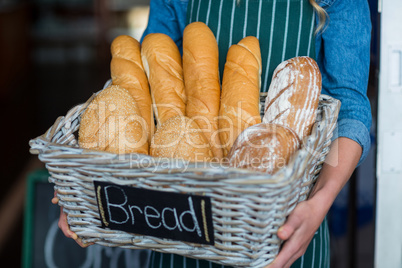 Female staff holding a basket of breads