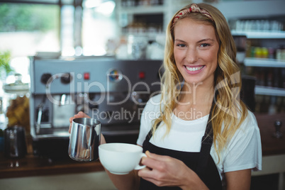 Portrait of smiling waitress making cup of coffee