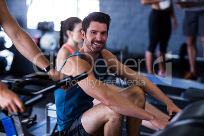 Happy young man exercising in gym