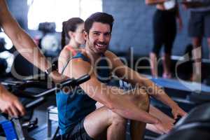 Happy young man exercising in gym
