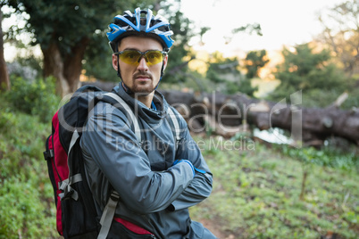 Portrait of male mountain biker with arms crossed in the forest