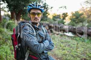 Portrait of male mountain biker with arms crossed in the forest