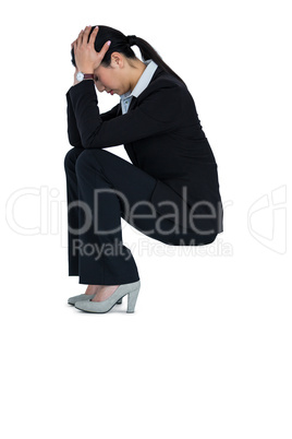 Depressed businesswoman sitting on steps with hand on head