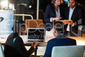 Businesspeople discussing over laptop and digital tablet