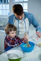 Father and son preparing cupcake