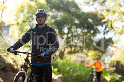 Male biker standing with mountain bike